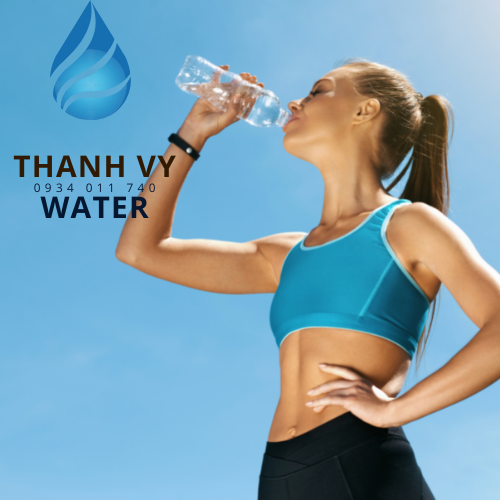 cô gái đang uống nước khi tập thể dục